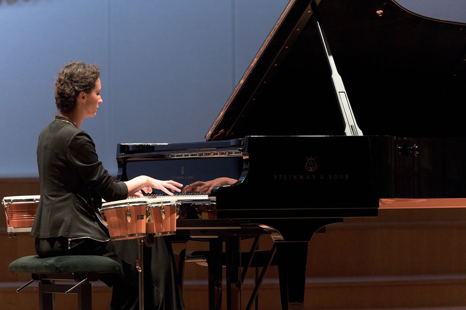 Žena v čiernom saku hrá na krídle