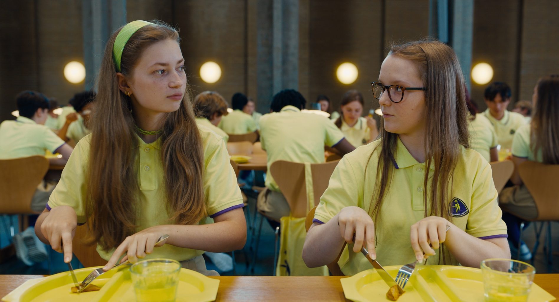 študentky Club Zero v žltých tričkách obedujú